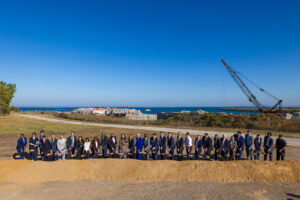 Group of people posing with shovels in the ground.